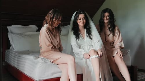 Bride Puts on Garter with Bridesmaids