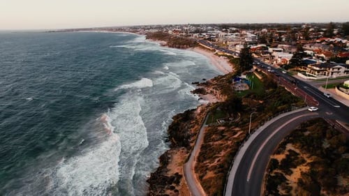 Aerial View of a Coastal Road Alongside a Beach at Dusk