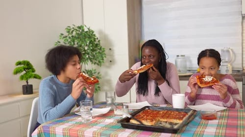 Family Together Eating Pizza in a Home Kitchen