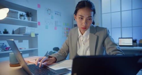 woman focus concentrate working on laptop and digital tablet check detail final work in office.