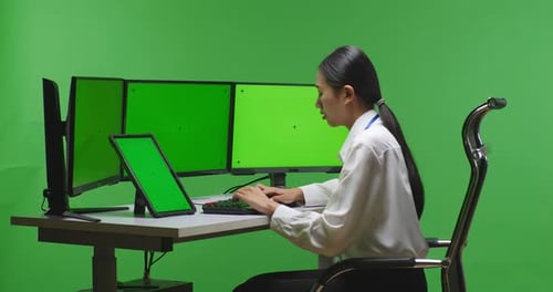 Woman Working With Tablet And Multiple Computer Monitor With Mock Up Green Screen In Green Screen