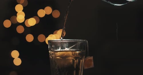 Pouring hot water on a cristal glass. Herbal infusion. Christmas background. Cozy coffee shop.