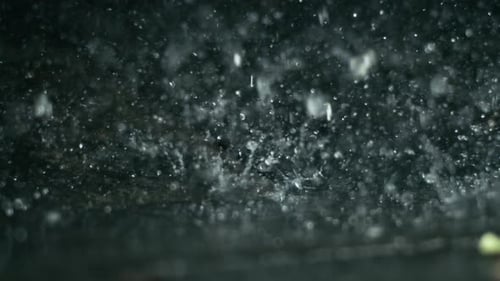 Ralentissements des gouttes de pluie sur fond sombre
