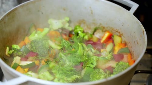 Hot Steam Rising From Vegetable Pot With Broccoli, Zucchini, Carrots. Slow Motion