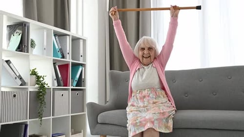 Cheerful Senior Woman Exercising with Cane Indoors