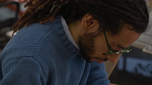 Young Man Taking Notes while Working with Colleague in Architectural Office