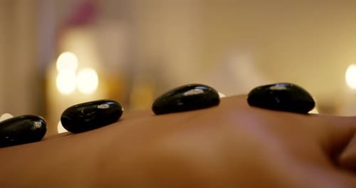 4k footage of a young woman getting a hot stone treatment at a day spa