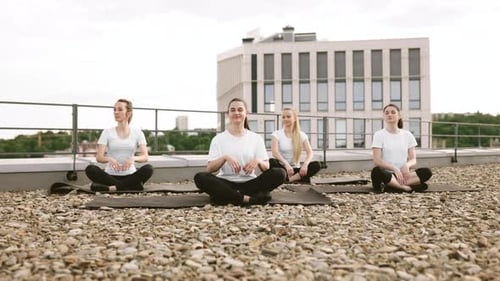 Four Women Meditating on a Rooftop
