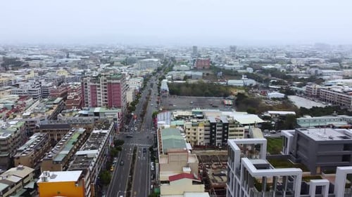Overcast cityscape with buildings stretching to the horizon, elevated view, subdued colors, urban