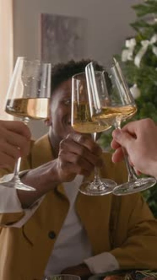 Happy Young Man Clinking Glasses with Anonymous Friends Celebrating Christmas