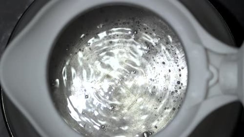 boiling water bubbles come up slow motion in silicone kettle closeup top view