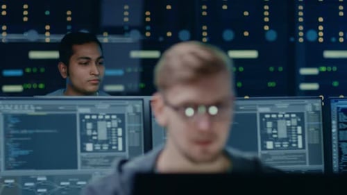 Portraits of Two IT Specialists Working on Personal Computers with Sophisticated Software In Techno