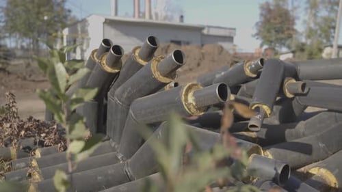 Pile of Insulated Pipes Outside on Sunny Day