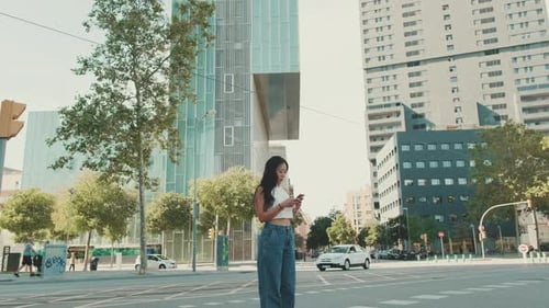 Woman Uses Phone on City Street