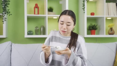 Young Woman Eating Food in Her Home