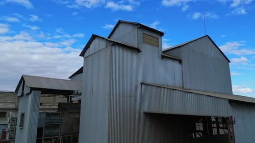 Farm with silo grain storage elevator in countryside. Small agriculture industry family business.