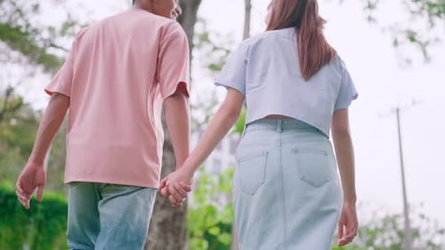 Young Couple Holding Hands Walking in the Park