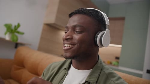 Young Man Listening to Music with Headphones at Home