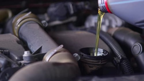 Sauberes neues Motoröl wird in der Werkstatt in den Automotor gegossen und aufgefrischt