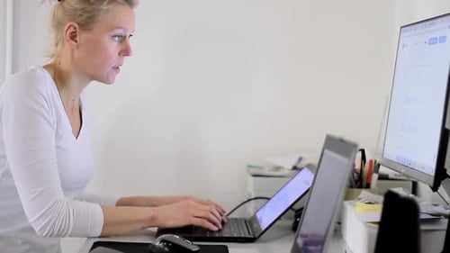 mujer secretaria en la oficina escribiendo en su portátil Vídeos de archivo