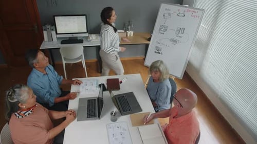 Woman Presenting Tech Concepts to Business Team