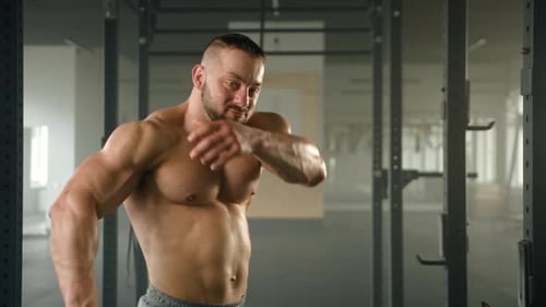 Muscular Man Flexing Biceps in Gym