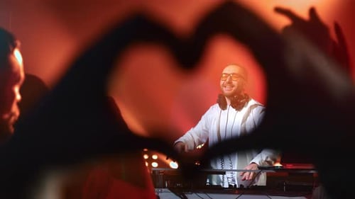 DJ Performs at a Nightclub with Heartfelt Crowd