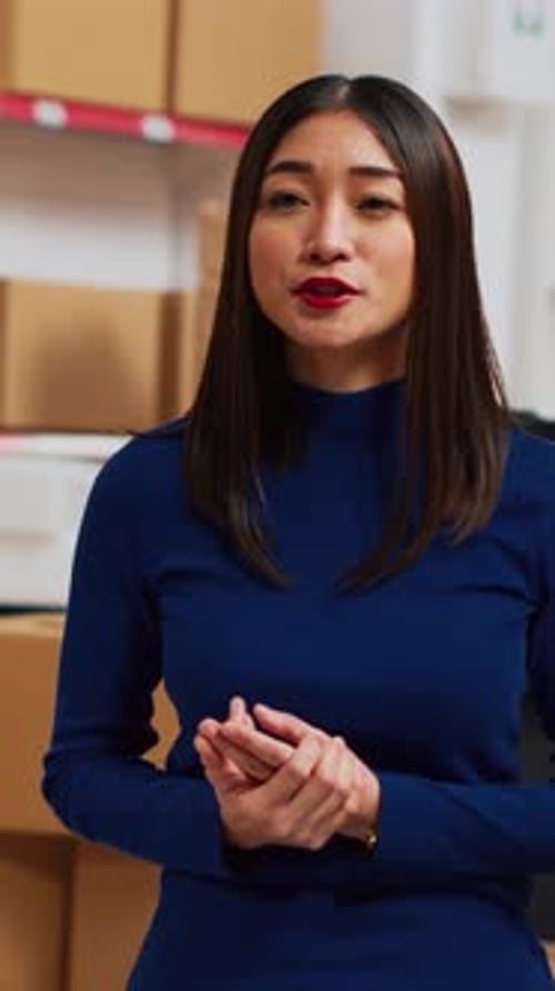 Woman Presenting in Office with Cardboard Boxes