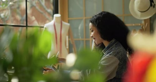 Junge Modedesignerin skizziert mit digitalem Stift auf dem Tablet