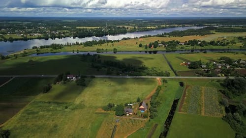 Stunning Aerial View of a Serene Countryside Featuring a River Flowing Through Lush Green Fields and