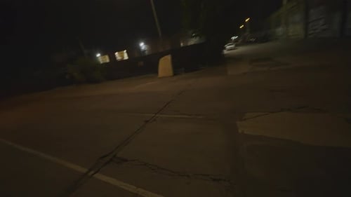 FPV drone shot of two police cars responding with flashing lights at night