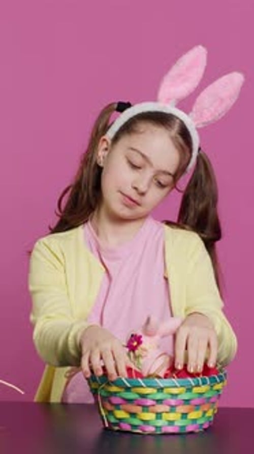 Vertical Video Sleepy Little Girl Yawning While She Arranges Easter Eggs for Festive Decorations