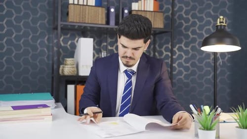 Man Reviews Business Document at Office Desk