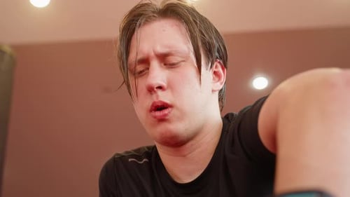 Male Fighter Breathing Heavily After Sparring in Gym Face Flushed with Effort