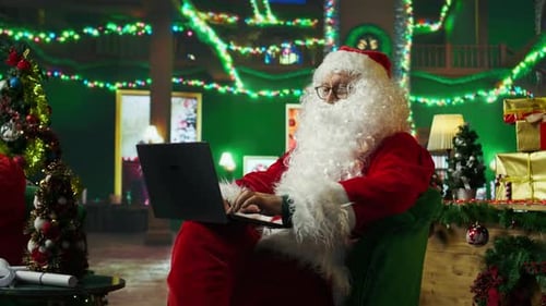 Santa Claus Typing on Laptop in Festive Room