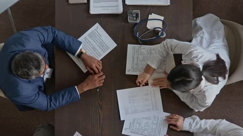 Top View of Hospital Director Arguing with Doctors at Staff Meeting