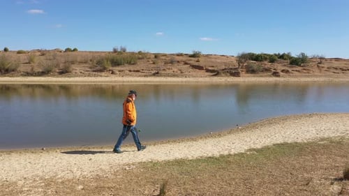 Photographer Walking By The Lake