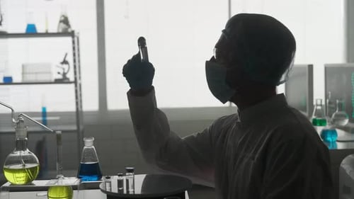 Research and Development of a Vaccine Dark Silhouette of a Male Scientist with a Glass Ampoule Vial