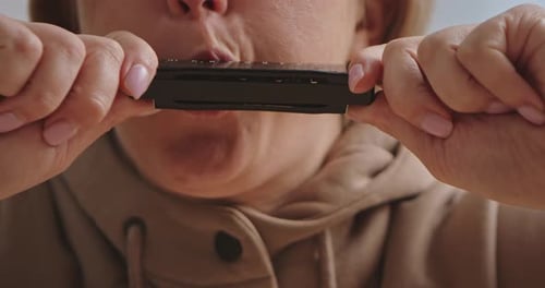 Close Up of Person Playing Harmonica with Focused Expression