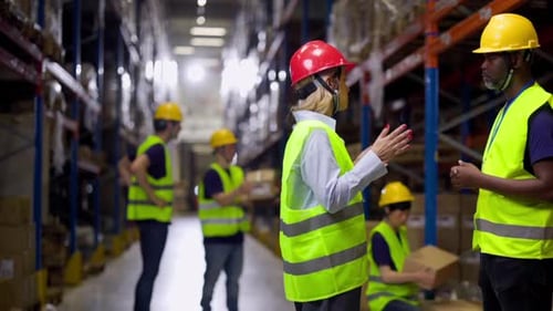 Warehouse workers discussing logistics and inventory management