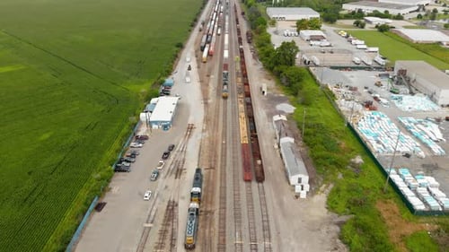 4k aerial view showing multiple trains parked at a train station waiting to leave