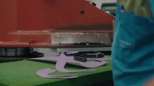 Man Using a Press to Cut Shapes from Leather