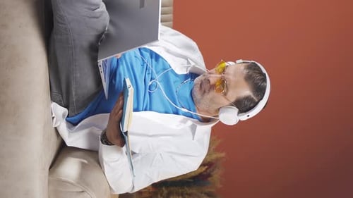 Vertical video of Man working on laptop with happy expression.