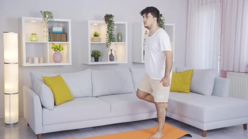 Man Stretching Legs on Yoga Mat at Home