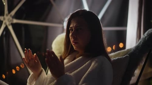 Une femme pensive bâille en regardant ailleurs sur une terrasse transparente