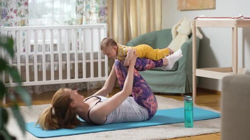 Woman Doing Abdominal Exercise With Baby on Legs