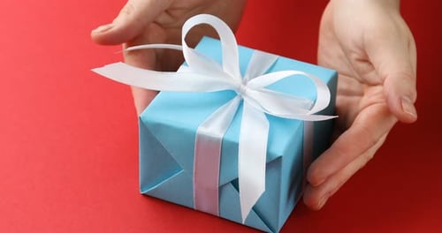 Light Blue Gift with White Ribbon on Red