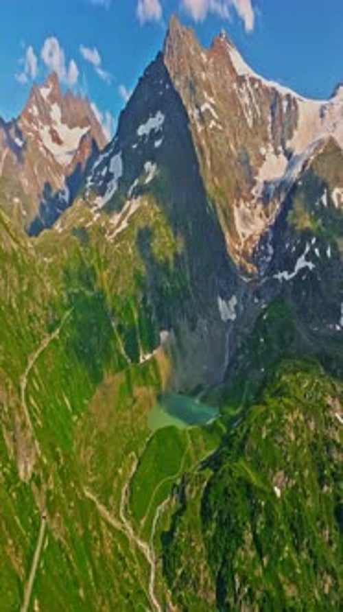 Drone Flies Over Green Picturesque Valley with Mountains in the Background High Mountains Famous