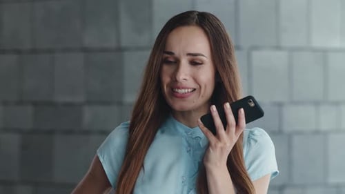 Smiling Business Woman Recording Voice Message on Smartphone in City. Positive Female