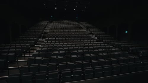 Empty Seats Folded Inside Theater Hall With Lights Turning On Before The Start Of A Spectacle. low a